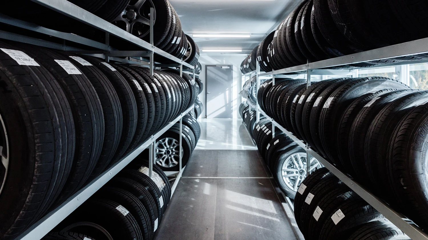 Plusieurs pneus de voitures rangés minutieusement.