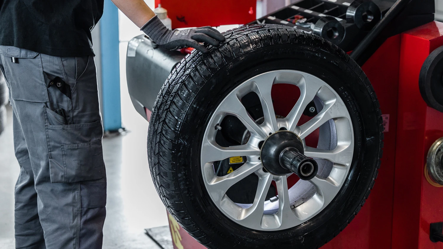Apprenti vérifiant la pression d'un pneu.